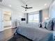 Bedroom boasts a large window, ceiling fan, gray color palette, and wood-look flooring at 11826 Sky Acres Ter, Bradenton, FL 34211