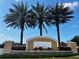 Elegant community sign with palm trees against a clear sky for a welcoming entrance at 11826 Sky Acres Ter, Bradenton, FL 34211