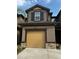 Charming two-story home with a tan garage door, beautiful stone accents, and manicured landscaping at 11826 Sky Acres Ter, Bradenton, FL 34211