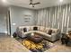 Bright living room features a comfortable sectional sofa, modern wall decor, and stylish tile flooring at 11826 Sky Acres Ter, Bradenton, FL 34211