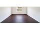 This is a bright bedroom with a window and dark wood-look flooring at 13202 Golf Ridge Pl, Hudson, FL 34669