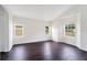 This expansive living room features natural light from multiple windows and dark-colored wood-look flooring at 13202 Golf Ridge Pl, Hudson, FL 34669
