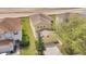Aerial view of a yellow two-story home featuring a two-car garage, driveway, and green lawn in a suburban neighborhood at 19648 Timberbluff Dr, Land O Lakes, FL 34638