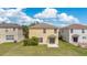 A two-story home with a light yellow exterior, small bushes, a blank concrete pad, and sliding glass doors to the backyard at 19648 Timberbluff Dr, Land O Lakes, FL 34638