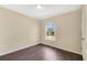 This bright bedroom features a window providing natural light and dark, modern flooring at 19648 Timberbluff Dr, Land O Lakes, FL 34638