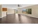 Open living area with dark floors, multiple windows, and sliding glass doors to the outside at 19648 Timberbluff Dr, Land O Lakes, FL 34638