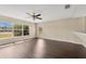 Spacious living area with large windows, dark floors, and a ceiling fan at 19648 Timberbluff Dr, Land O Lakes, FL 34638
