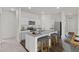 Bright kitchen featuring white cabinets, a granite countertop island with seating, stainless steel appliances, and modern finishes at 14699 Italy Ave, Dade City, FL 33523