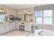 Luxurious bathroom with a double vanity, large window, and elegant finishes at 1785 Trailhead Ln, Zephyrhills, FL 33541
