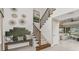 Bright entryway features stylish decor, staircase with iron spindles, and a comfortable bench for a welcoming entrance at 1785 Trailhead Ln, Zephyrhills, FL 33541