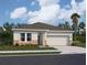 Charming single-story home featuring stone accents, a two-car garage, and a well-manicured lawn at 36157 Canelli Way, Dade City, FL 33523