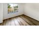 Bedroom with wood floors and a large window providing natural light and neighborhood views at 1238 Standridge Dr, Wesley Chapel, FL 33543