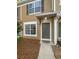Exterior shot of a tan townhome featuring well-kept landscaping and a covered front entrance at 1238 Standridge Dr, Wesley Chapel, FL 33543
