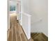 Hallway featuring wood-look floors, access to other rooms, and a carpeted staircase at 1238 Standridge Dr, Wesley Chapel, FL 33543