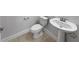 Cozy bathroom with pedestal sink, toilet, and tile flooring providing functionality and comfort at 1998 Milkweed Trce, Lutz, FL 33558