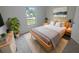 Cozy bedroom featuring neutral tones, a comfortable bed, and a large window offering ample natural light at 27118 Fernery Ave, Brooksville, FL 34602