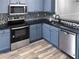 Beautiful blue kitchen features stainless steel appliances and dark countertops at 6122 Osprey Lake Cir, Riverview, FL 33578