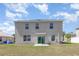 Exterior of home from backyard view showcasing large windows, sliding glass door, and grass yard at 11807 Myrtle Rock Dr, Riverview, FL 33578