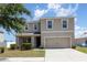 Inviting two-story home with a well-maintained lawn and a two-car garage at 11807 Myrtle Rock Dr, Riverview, FL 33578