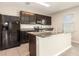 Kitchen featuring dark cabinets, granite countertops, a peninsula, and black appliances at 11807 Myrtle Rock Dr, Riverview, FL 33578