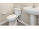 Cozy powder room featuring a pedestal sink and toilet at 11807 Myrtle Rock Dr, Riverview, FL 33578