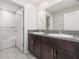 A bathroom with a double vanity, granite countertops and a white-tiled shower/tub combination at 13581 Willow Bluestar Loop, Riverview, FL 33579