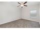 This bedroom features gray carpet, a ceiling fan with light, and a window providing natural light at 13581 Willow Bluestar Loop, Riverview, FL 33579