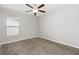 This bedroom features gray carpet, a ceiling fan with light, and a window providing natural light at 13581 Willow Bluestar Loop, Riverview, FL 33579