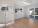 Bright bathroom with glass-enclosed shower, modern lighting, and sliding door access to outdoor space at 1404 Rosewood Ave, Dunedin, FL 34698
