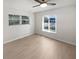 Bedroom features light wood floors, a ceiling fan, and natural light from two windows at 1404 Rosewood Ave, Dunedin, FL 34698