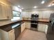 Modern kitchen featuring stainless steel appliances, granite countertops and white cabinetry at 1404 Rosewood Ave, Dunedin, FL 34698