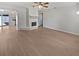 Open living room with wood floors and white brick fireplace, seamlessly connected to the kitchen at 1404 Rosewood Ave, Dunedin, FL 34698