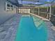 Backyard pool with screened enclosure and paved patio area at 1404 Rosewood Ave, Dunedin, FL 34698