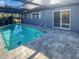 Backyard pool with screened enclosure and paved patio area at 1404 Rosewood Ave, Dunedin, FL 34698