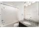 This bathroom features white tiled walls, granite counters, and a bathtub with a shower at 5710 Colony Glen Rd, Lithia, FL 33547