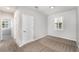 This cozy bedroom features neutral carpet, light-colored walls, a window with shutters, and a hallway to another room at 5710 Colony Glen Rd, Lithia, FL 33547