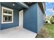 Home exterior featuring textured blue walls, a front door and a nearby window at 5710 Colony Glen Rd, Lithia, FL 33547