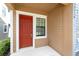 A close-up of the home's inviting red front door with white trim and adjacent window at 5710 Colony Glen Rd, Lithia, FL 33547