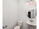 A clean half bathroom features a pedestal sink, toilet, and modern lighting at 5710 Colony Glen Rd, Lithia, FL 33547