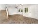 Bright living room with wood-look flooring, shuttered windows, and staircase access at 5710 Colony Glen Rd, Lithia, FL 33547