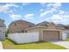 Exterior shot of home with a two car garage and fenced yard at 13417 Lake Monroe Pl, Riverview, FL 33579