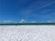 Beautiful white sand beach with clear blue sky and calm turquoise water at 26187 Argentina Dr, Punta Gorda, FL 33983