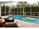 Enclosed pool area with blue and yellow floaties and comfortable wooden furniture for lounging at 26187 Argentina Dr, Punta Gorda, FL 33983