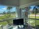 The sunroom is surrounded by large windows with a lush view at 26187 Argentina Dr, Punta Gorda, FL 33983