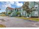 Inviting two-story condo featuring a unique green exterior, tidy landscaping, and staircase entrance at 10520 Windsor Lake Ct # 10520, Tampa, FL 33626