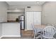 Open kitchen with stainless steel refrigerator, modern appliances, and eat-in table with white chairs at 10520 Windsor Lake Ct # 10520, Tampa, FL 33626