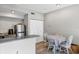 Open kitchen with stainless steel refrigerator, modern appliances, and eat-in table with white chairs at 10520 Windsor Lake Ct # 10520, Tampa, FL 33626