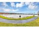 Scenic view of a tranquil lake surrounded by lush greenery and colorful buildings under a blue, cloudy sky at 10520 Windsor Lake Ct # 10520, Tampa, FL 33626