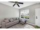 Comfortable living room featuring modern ceiling fan, wood-look floors, and natural lighting at 10520 Windsor Lake Ct # 10520, Tampa, FL 33626