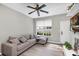 Comfortable living room featuring modern ceiling fan, wood-look floors, and natural lighting at 10520 Windsor Lake Ct # 10520, Tampa, FL 33626